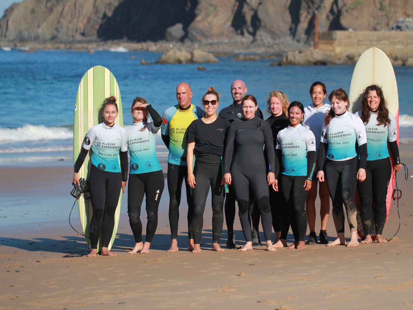 The retreat group on the sand with boards, cliffs behind