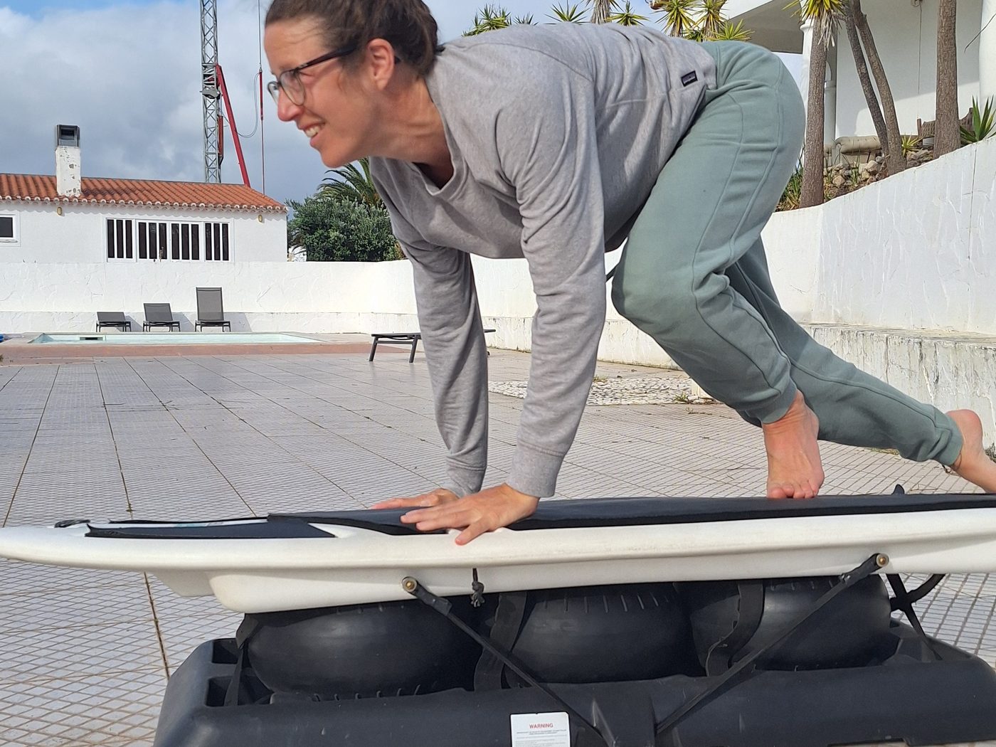 A participant practising the pop-up on a Surfset trainer board on the terrace